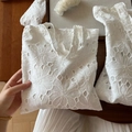 Detail of white cotton handbag featuring intricate floral embroidery and hollow-out design - Vertical Handbag Small