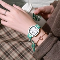 Detail shot of a minimalist square quartz watch with a green fabric strap on wrist - Green