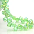 Macro shot of grass green faceted teardrop crystal beads with rainbow AB coating - Fruit Green AB / 6mm (approximately 87 Beads Per Strip)