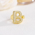 Close-up of golden letter B ring with sparkling cubic zirconia pavé setting detail - Letter B / Gold