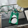 Détail du sac tricoté panda vert montrant la texture, le bouton et la sangle - Panda Vert (Sac de Téléphone)