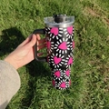 Detail of 40oz insulated tumbler with pink heart pattern and ergonomic handle on grass - A4 / Pink Radiating Heart