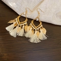 Detail of bohemian gold leaf earrings with white tassels and intricate bead accents - White Tassel Leaf Ear Hook