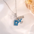 Silver chain necklace featuring blue enamel airplane, passport, and boarding pass charms - Silver Airplane Travel Passport Style