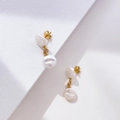 Detail of elegant gold-plated drop earrings featuring two white baroque pearls and studs - Two Flat Pearl Style