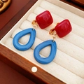 Dettaglio macro di orecchini in resina a forma di quadrato rosso e goccia blu - Stile Clip per Orecchio - Quadrato Rosso Goccia d'Acqua Blu Pendente