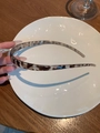 Detailed view of a slender tortoiseshell resin headband held by hand in natural light - PC Light Tortoise Hairband