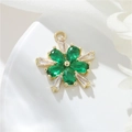 Macro detail of a 14k gold plated flower pendant with green stones and white crystals - H-10760 Snowflake Flower