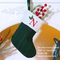Green knitted Christmas stocking featuring red letter N embroidery and holly berries - Letter N / Dark Green