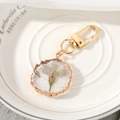 Detail of handmade resin keychain featuring purple dried flowers and gold leaf accents - Light Blue Flower
