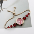 Detail of gold women's watch with red heart gemstones and pink marble dial texture - Rose Gold Red