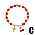 Primer plano de pulsera de cuentas rojas y doradas con dijes de cereza y cruz sobre blanco - Colgante Cruz Cereza (C)