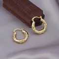 Elegant gold bamboo joint hoop earrings displayed on luxurious purple silk fabric - Bamboo Joint Shape / E-044---Gold