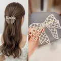 Elegant gold-tone bow hair clip with white pearls and rhinestones shown in hand and worn - Romantic Lace Net Pearl Bow Spring Clip