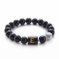 Close-up of 10mm black onyx beads with a white turquoise stone and golden letter E bead - Letter E