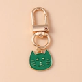 Detailed close-up of a green enamel cat head keychain charm with golden metal accents - Green Cat Head Style