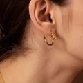 Minimalistischer, 18k vergoldeter Knoten-Ohrring aus Edelstahl am Ohr eines Frauenmodells - Gold