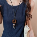 Detail of bohemian long necklace featuring brown square pendant and silver metal charms - 96# Brown Cube Hollow Ball