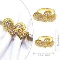 Gold heart-shaped napkin ring featuring overlapping double heart design with rhinestones - Golden Linked Hearts White Zirconia