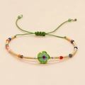 Bracciale di perline colorate stile boho con ciondolo a fiore verde e cordino regolabile - Fiore Verde Con Perline Dorate