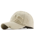 Close-up of distressed beige cotton baseball cap with vintage frayed edges and texture - Beige