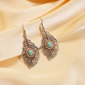 Detailed view of bohemian leaf earrings with turquoise stones on gold silk background - Earring Hooks - Silver