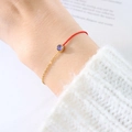 Minimalist red woven string bracelet with gold chain and round purple gemstone detail - February Purple