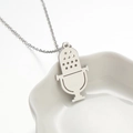 Collana con pendente a microfono in acciaio argento su un piatto di ceramica bianca - Color Acciaio