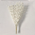 Detailed close-up of white decorative berry stems with pearlescent finish for holiday decor - White