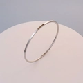 Polished silver minimalist stainless steel bangle shown on a pink pedestal - Inner Diameter 60 / Steel