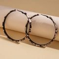 Macro detail van retro luipaardprint oorringen met vintage geometrische patroontexturen - Luipaardprint Zwarte Ring
