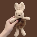 Cute beige plush rabbit hair scrunchie made of soft fleece held against a dark background - Rabbit Coffee