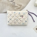 Close-up of quilted cosmetic bag with cute rabbit patterns and a purple woven handle - Star Rabbit