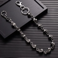 Detalle de cadena de calaveras plateada estilo punk con cierre sobre fondo negro - Cadena de cintura de calavera / Plata Antigua