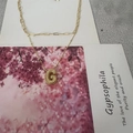Collier double couche doré avec pendentif lettre G sur carte décorative fleurie - Lettre G
