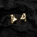 Pendientes de onda dorados irregulares minimalistas con textura artística sobre fondo negro - Dorado