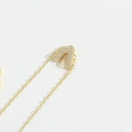 Golden necklace with crystal-paved letter A pendant on delicate chain in close-up view - Letter V