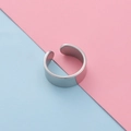 Primer plano de un anillo ajustable plateado en forma de C sobre un fondo pastel bitono - US 7 / 8mm de Ancho / Color Acero