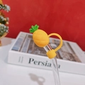 Detail view of a yellow silicone pineapple straw cover on a clear glass drinking straw - Pineapple Straw Cover