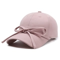 Pink cotton baseball cap with ribbon bow accent for women shown on white background - Pink