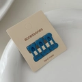 Detailed view of three blue bone-shaped mini hair clips on a card inside a ceramic bowl - Dark Blue (Set of 4)