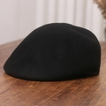 Detailed close-up of a vintage black wool felt ivy cap on a dark wood background - M (56-58cm) / Black
