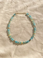 Flat lay of cat-eye stone beads necklace with golden clasp on beige linen fabric - Blue Cat's Eye with Melon Buckle 38+5cm