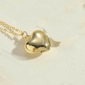 Close-up of polished gold heart pendant necklace on a textured stone background - Medium (2.0cm) / Gold