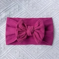 Detailed view of deep pink cable-knit nylon baby headband with a large bow detail - Deep Purple