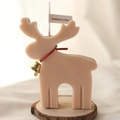 Handmade light brown reindeer candle with a gold bell on a rustic wooden base - Milk Tea Reindeer