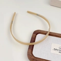 Gros plan d'un serre-tête beige montrant les dents antidérapantes sur un plateau en bois - Khaki