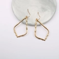 Golden irregular hollow teardrop earrings on marble display with minimalist modern design - Gold