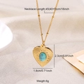 Golden heart necklace with turquoise stone inlay and ribbed edge on beige fabric - Heart