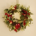 Artificial Christmas wreath with pine cones red berries and warm LED lights on a white wall - Lamb's Ear Leaf Red Berry Wreath (With Light)